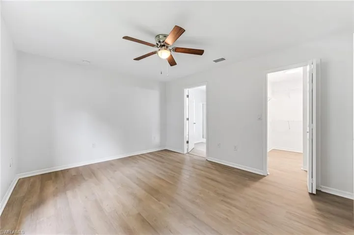 Empty room featuring light wood-type flooring and ceiling fan