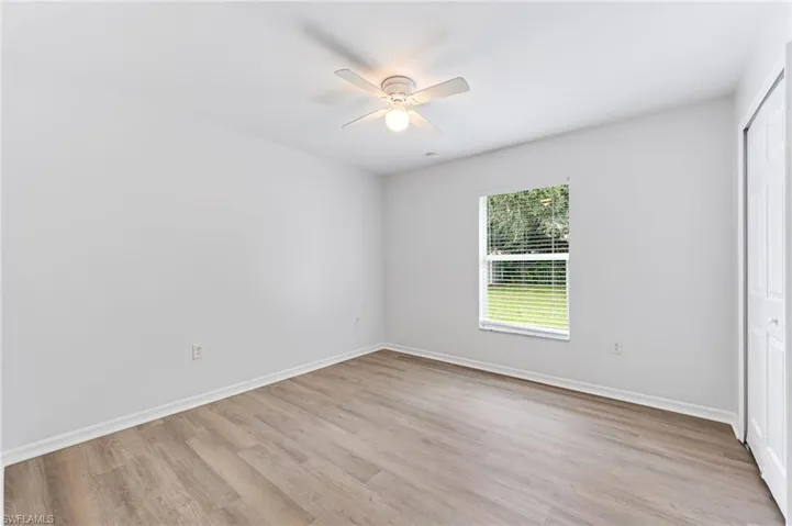 Unfurnished bedroom with ceiling fan, a closet, and light wood-type flooring