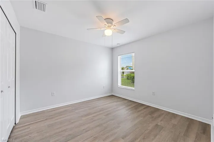 Unfurnished bedroom featuring light hardwood / wood-style flooring, ceiling fan, and a closet