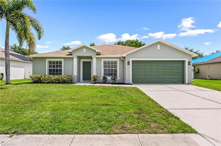 Single story home with a garage and a front yard