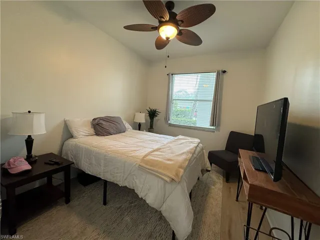 Bedroom featuring light hardwood / wood-style floors, ceiling fan, and vaulted ceiling