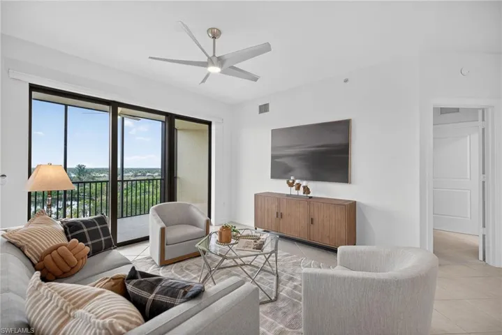 Living room featuring light tile patterned floors and ceiling fan