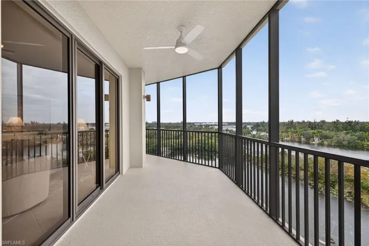 Unfurnished sunroom with a wall of windows, a textured ceiling, a water view, and carpet flooring