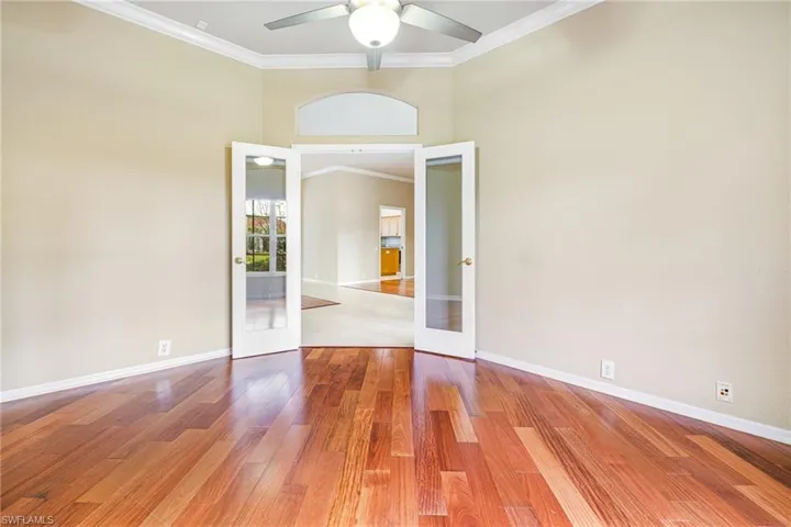Den or Study with Santos Mahogany flooring, French Doors, ceiling fan, and crown molding