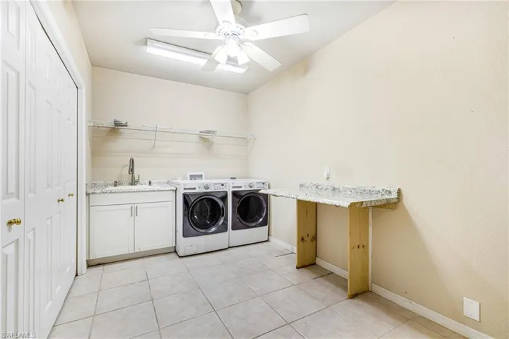 Huge Laundry room with sink, washer and dryer, folding area, ceiling fan, and tons of storage