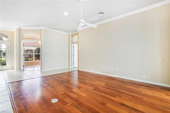 Formal Living Room featuring ceiling fan, Santos Mahogany hardwood flooring, and ornamental molding (study is in the background)