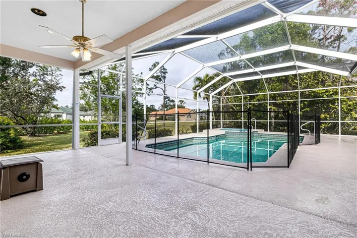 View of pool featuring a patio and spa area and a large screened lanai