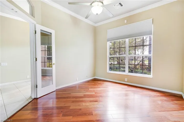 Den or Study (unstaged) with Santos Mahogany flooring, French Doors, ceiling fan, and crown molding