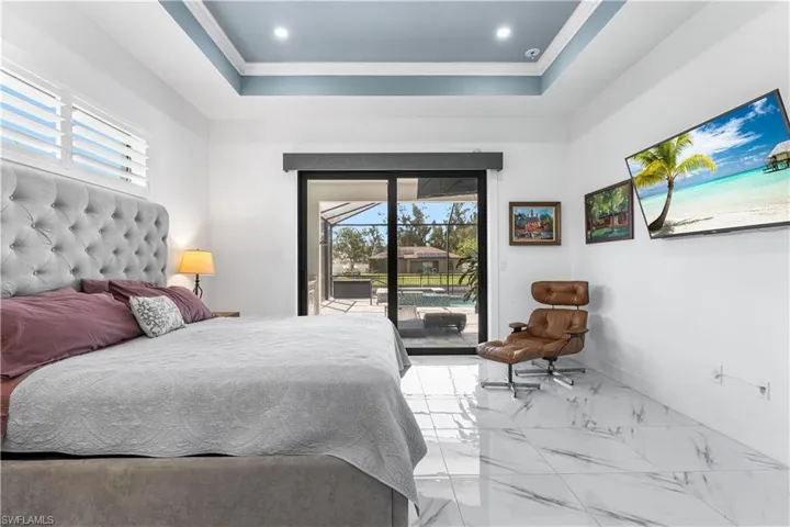 Primary bedroom, with sliding glass door leading to lanai and pool.