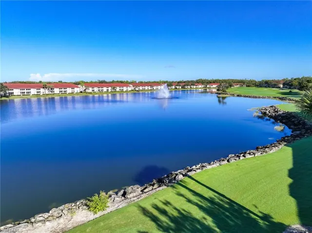 Expansive lakefront setting featuring a central water fountain, rock-lined shoreline, and manicured green space