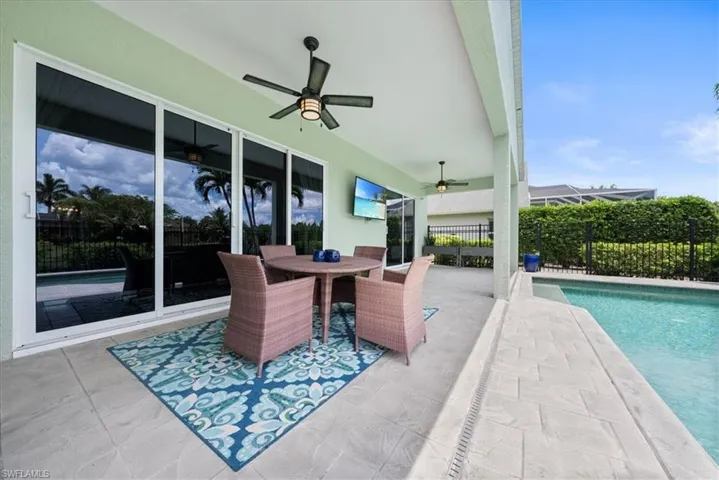 View of terrace featuring ceiling fan and a fenced in pool