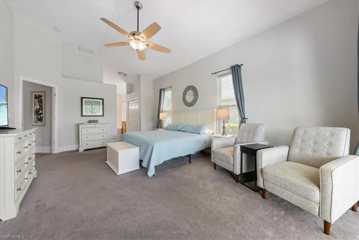 Bedroom with a towering ceiling, carpet flooring, and ceiling fan