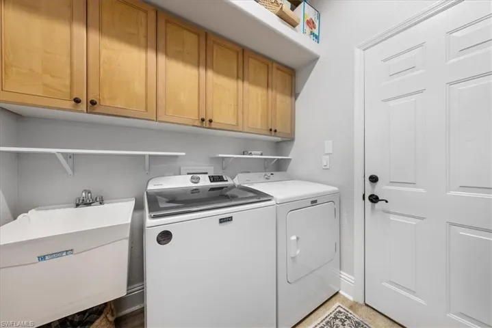 Washroom featuring cabinets, sink, hookup for a washing machine, and washing machine and clothes dryer