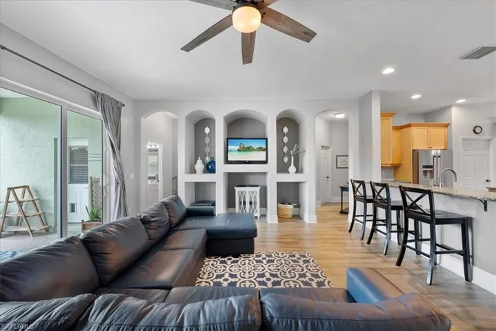 Living room featuring built in features, ceiling fan, light hardwood / wood-style floors, and sink