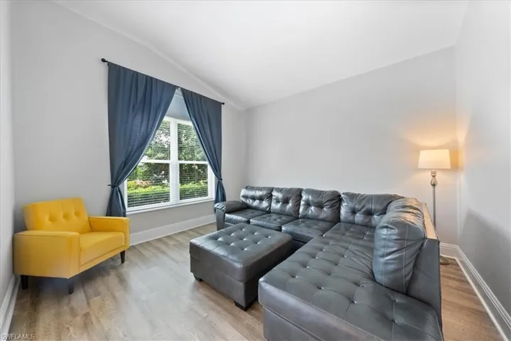 Living room with hardwood / wood-style floors and lofted ceiling