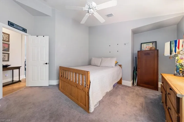 Carpeted bedroom featuring ceiling fan