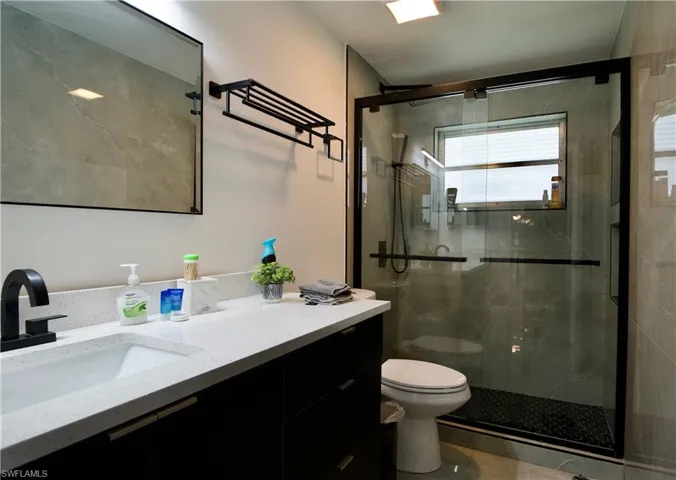 Bathroom featuring vanity, a shower stall, and tile patterned flooring