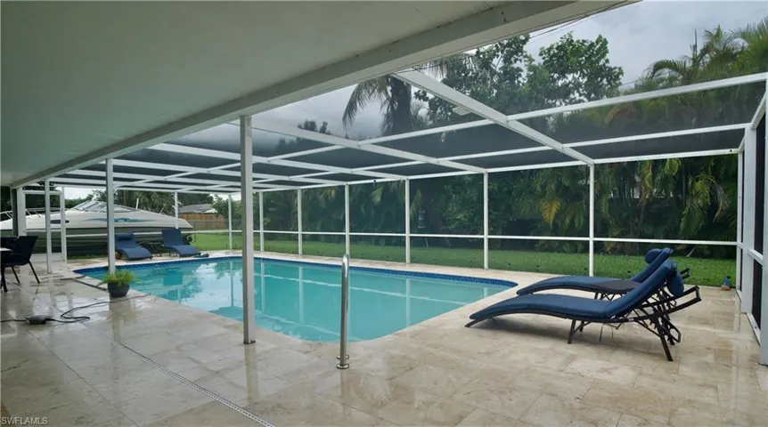 Swimming pool featuring a patio, a sunroom, and a lanai