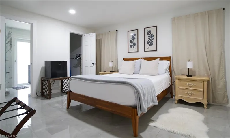 Bedroom with a walk in closet, ensuite bath, and recessed lighting