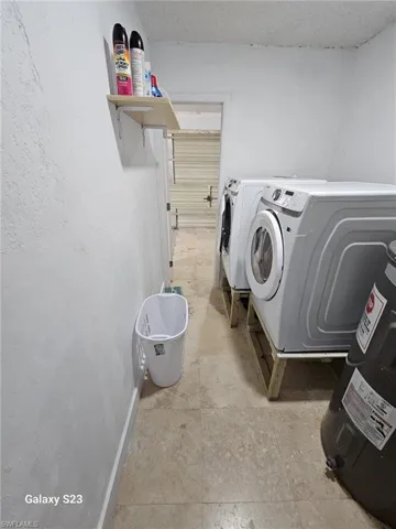 Laundry area featuring water heater and washer and dryer
