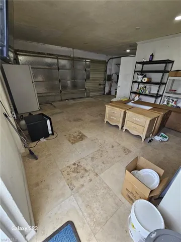 Below grade area featuring a garage and freestanding refrigerator