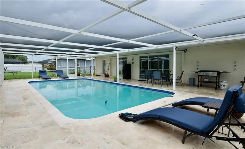 View of pool with a patio area and a lanai
