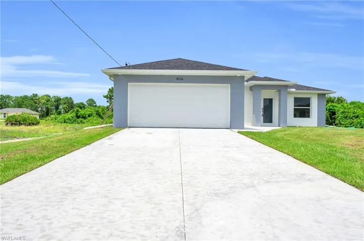 View of front of home featuring a garage and a front yard
