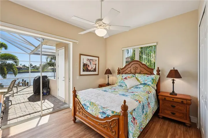 Bedroom featuring a closet, a sunroom, access to exterior, and wood finished floors