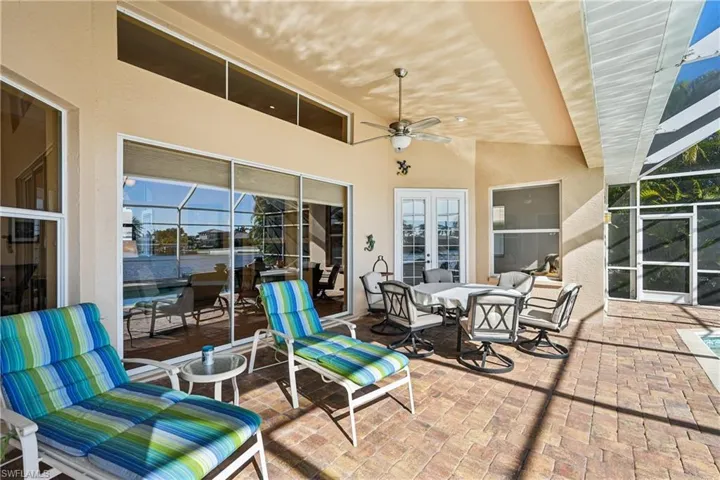 View of patio with ceiling fan, a lanai, and outdoor dining space