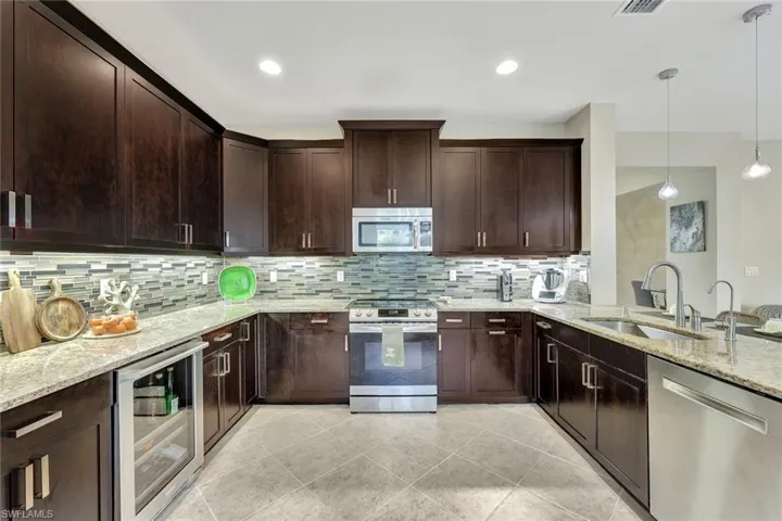 * Chef’s kitchen featuring custom Salem Maple Espresso cabinets, granite countertops, and top-of-the-line stainless steel appliances, designed for culinary excellence.