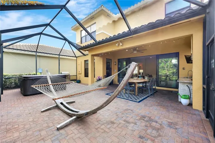 View of patio / terrace with a hot tub, glass enclosure, and ceiling fan