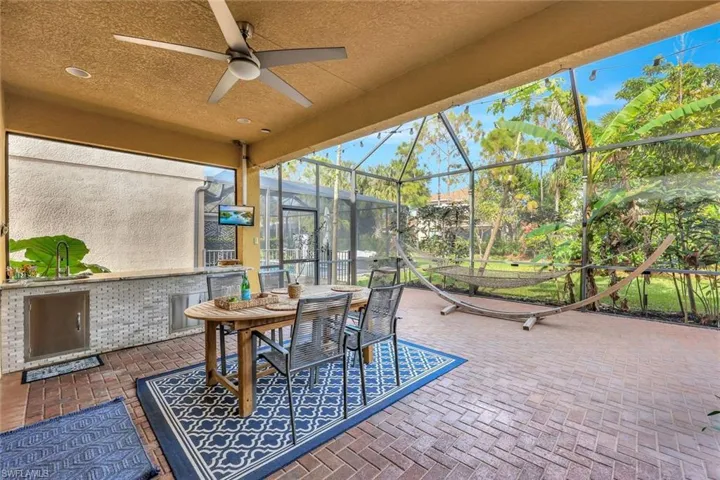 View of patio featuring ceiling fan and a lanai