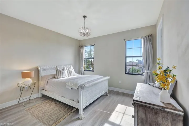 Bedroom featuring light wood-type flooring and a notable chandelier