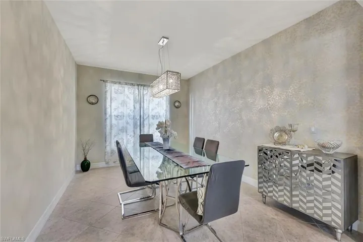 Elegant dining space with a statement chandelier , creating a picturesque setting for family meals and formal occasions