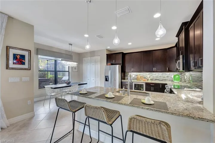 Kitchen featuring sink, hanging light fixtures, tasteful backsplash, under counter gourmet light, kitchen peninsula counter top dinning, and stainless steel appliances
