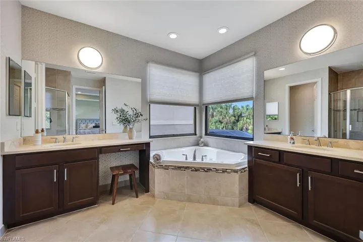 At the core of your grand master suite lies the luxurious master bathroom, a spa-inspired haven of relaxation. Featuring a frameless glass shower, a jetted soaking tub, and dual vanities with quartz countertops, this space exudes elegance. Custom tilework, elegant wallpaper, oversized mirrors, and natural light enhance its sophisticated ambiance. Leading to it is a hallway with expansive walk-in closets, offering ample storage and seamless flow