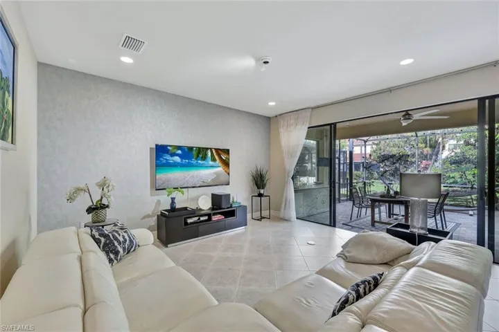 Spacious main living room area featuring diagonally installed tile flooring, recessed lighting, and large windows for a bright and airy ambiance, perfect for both relaxing and entertaining