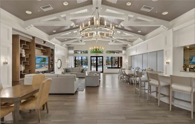 Living area with a notable chandelier, visible vents, wooden ceiling, and beam ceiling