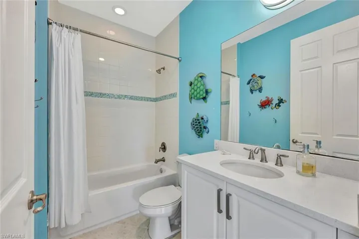Full bathroom featuring tile patterned flooring, vanity, shower / bath combination with curtain, and toilet