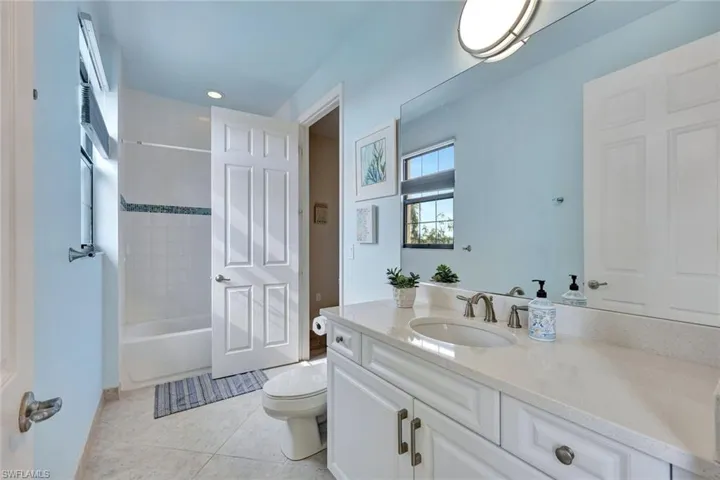 Full bathroom featuring tile patterned floors, vanity, toilet, and tiled shower / bath