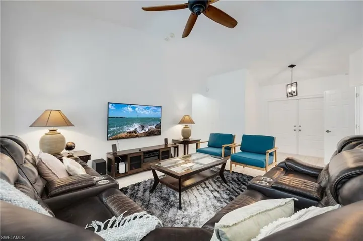 Living area with a ceiling fan and vaulted ceiling