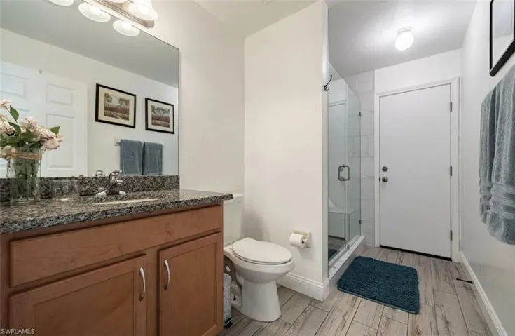 Bathroom featuring vanity, a stall shower, and wood tiled floors