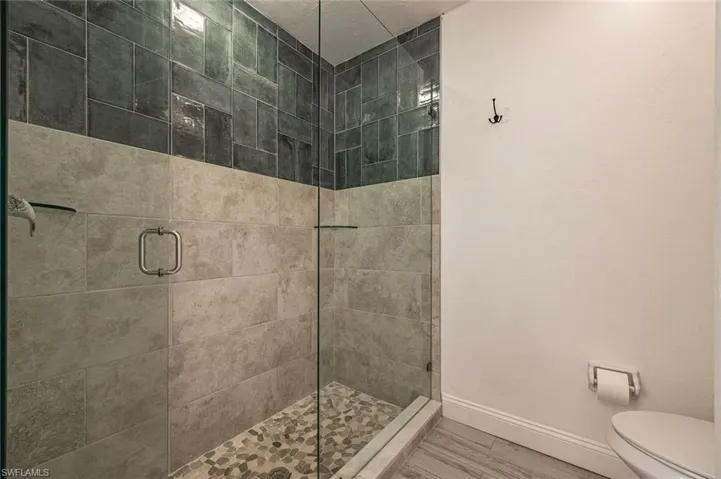 Full bathroom featuring a stall shower and wood finished floors