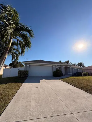 Ranch-style house featuring a garage, concrete driveway, and stucco siding
