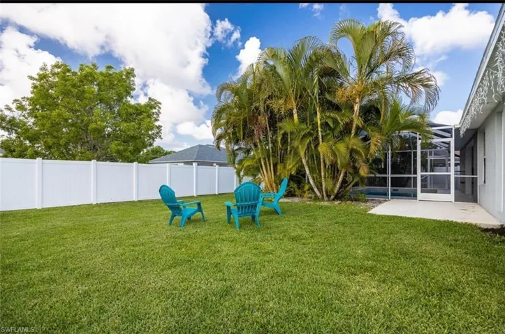 Fenced yard featuring a sunroom and a lanai