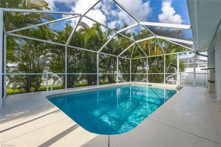 Swimming pool with a sunroom, glass enclosure, and a patio area