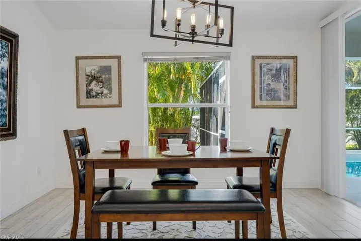 Dining space with light wood-style flooring, suspended lighting, and plenty of natural light
