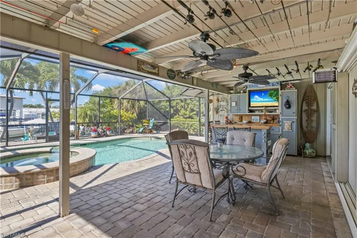 Private waterfront retreat with a sparkling saltwater pool, spa, child safety barrier, custom poolside bar, and new pool cage (2022) ideal for relaxation and entertaining.