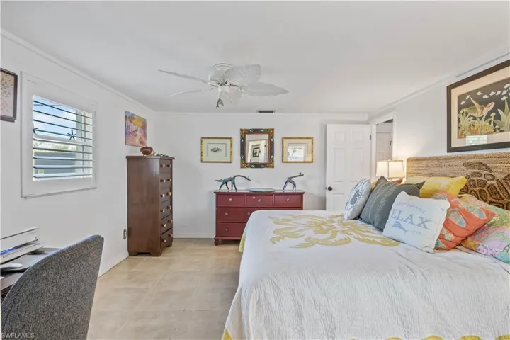 Elegant primary bedroom featuring large windows framing tranquil outdoor scenery.