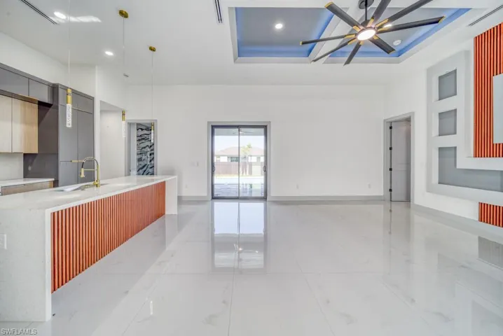 Kitchen with modern cabinets, a ceiling fan, light countertops, a sink, and recessed lighting